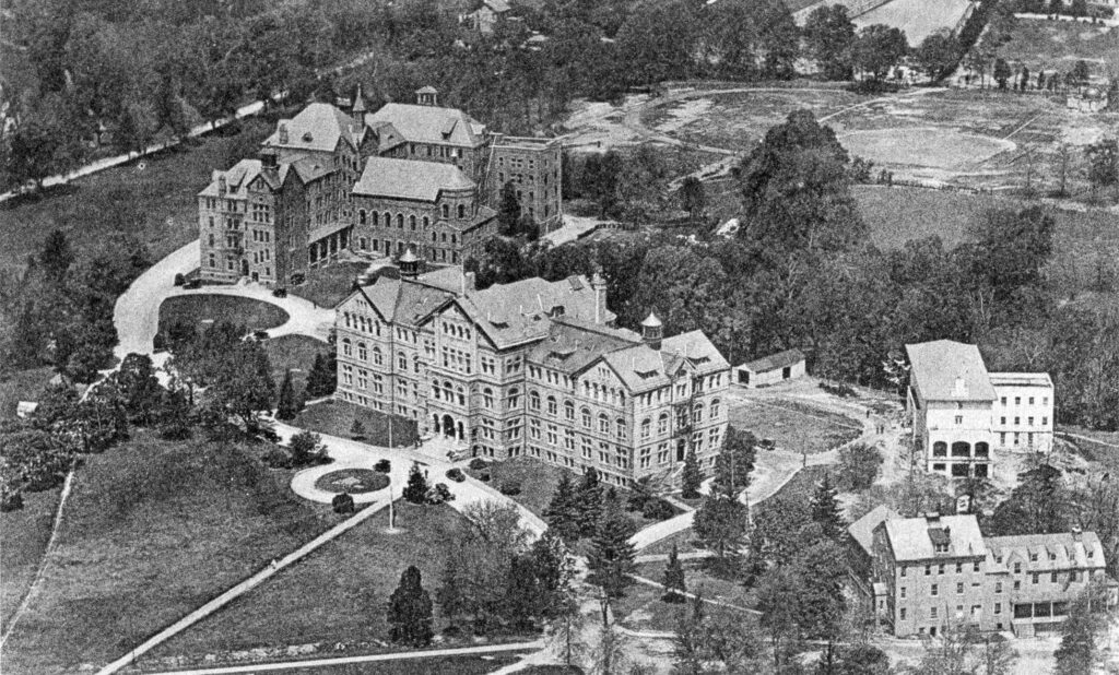 An aerial view of the Catholic University of America, 1920. The complex includes two large multistory buildings and two smaller ones.