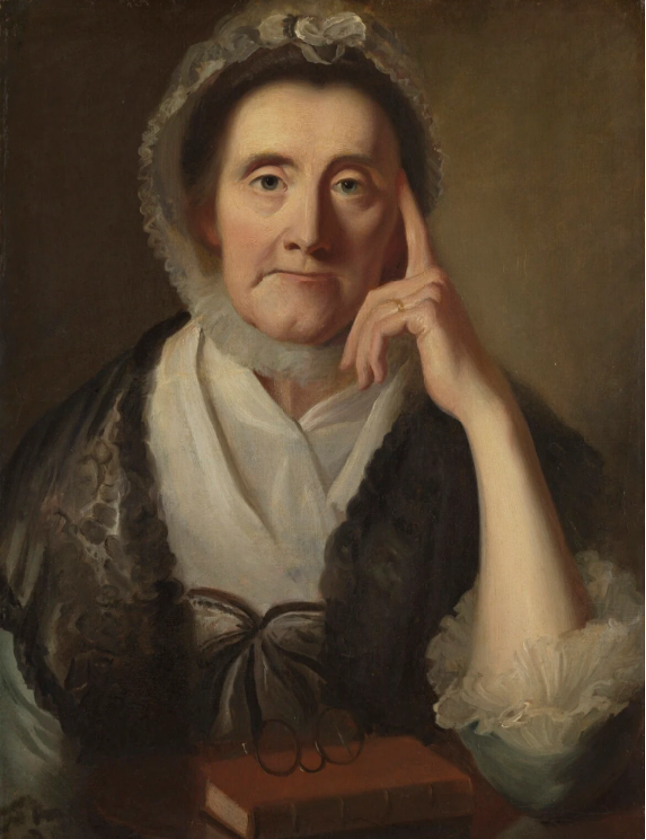 Portrait of the Countess of Huntingdon, Selena Hastings, in a lace headcovering with a bow, a white blouse with ruffles, and a velvet cape in a dark color. She has a serene expression, but with one finger to her temple, appears to be thinking. She was an important benefactor of the Methodist cause.