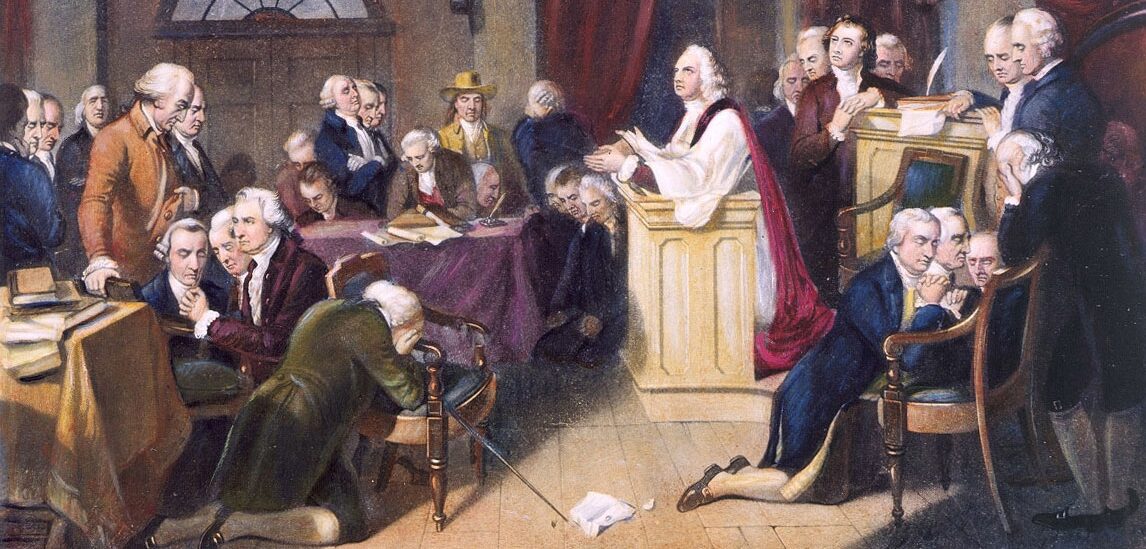 Painting depicting the first prayer of the Continental Congress in 1774. Some members stand with heads bowed while others kneel with clasped hands. A minister draped in white and red stands at the pulpit with outstretched hands and eyes looking heavenward.